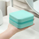 Porta-Jóias de Viagem Compacto com forro de veludo e divisórias removíveis. Ideal para organizar e proteger anéis, pulseiras, brincos e colares durante viagens. Design elegante e prático, perfeito para levar na bolsa e dar de presente.